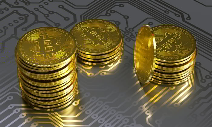 An illustration of Bitcoin tokens on a circuit board.